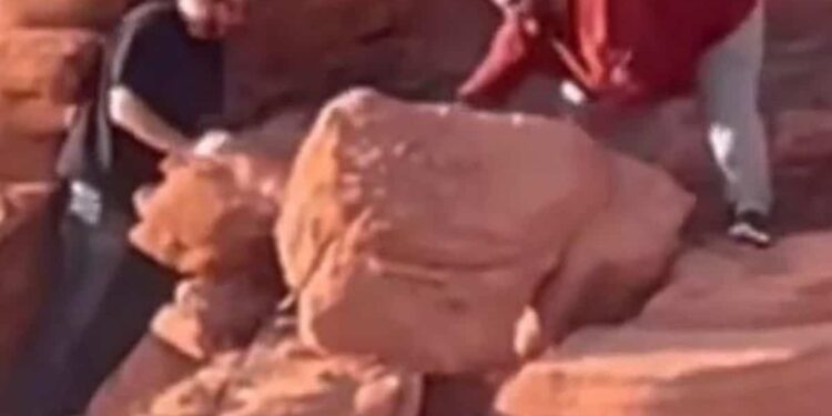 Two visitors damage ancient rock formations at a protected site